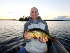 Guest Holding Fish Caught on the Lake